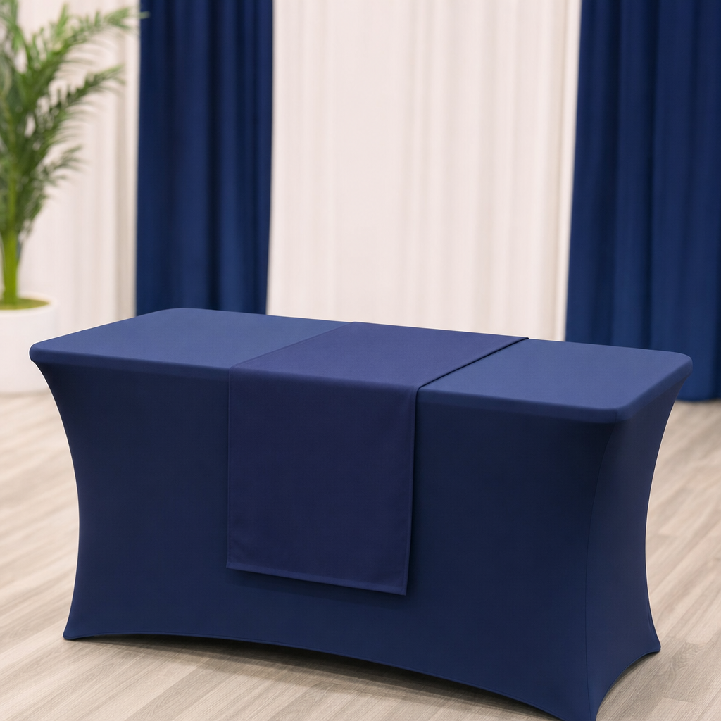 A blank fitted fabric table cover and a matching runner on a booth table under soft light